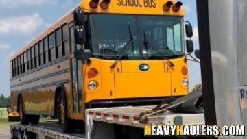 Bus transported on a step deck trailer.