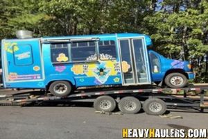 Loading a Ford shuttle bus on a trailer.