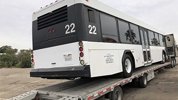 Hauling a bus on a drop deck trailer.