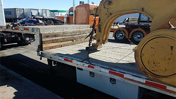 Transporting a draft arm on a drop deck trailer.