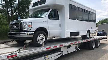 Hauling a Ford shuttle bus on a stepdeck trailer.