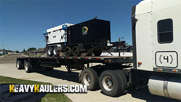 Trasporting an Ingersol generator on a flatbed trailer.