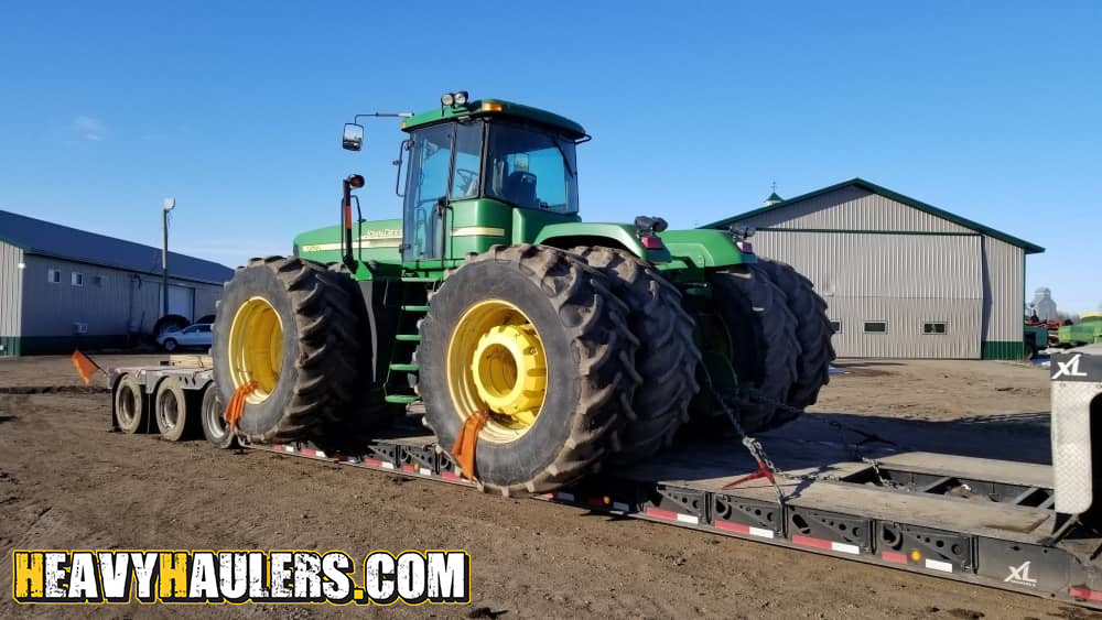 Green tractor shipped on a trailer.