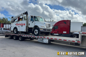 Transporting a service truck on a step deck trailer.