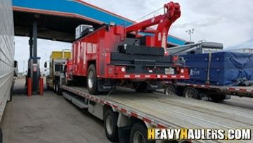 Service truck transported on a step deck trailer.