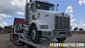 Semi truck shipped on a step deck trailer.