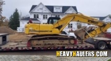 Transporting a Kobelco excavator on a trailer.