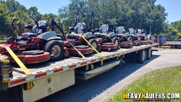 lawn mowers being transported on a trailer