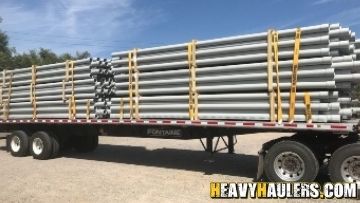 Shipping PVC pipes on a flatbed trailer.