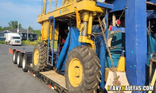 Transporting a grape harvester on a lowboy trailer.